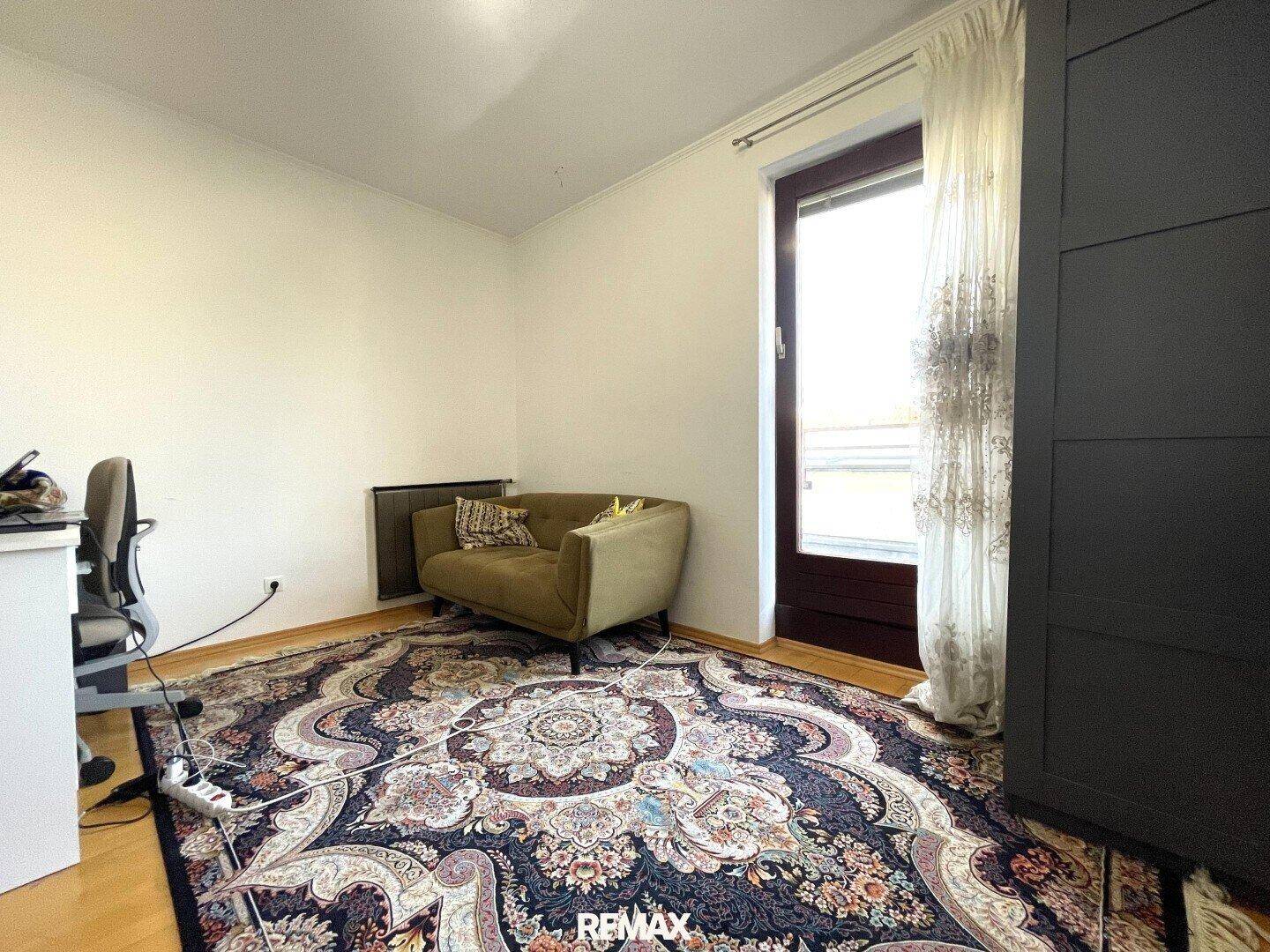 Kleines Zimmer mit Schreibtisch, Sessel und Fenster, ideal als Büro oder Gästezimmer.