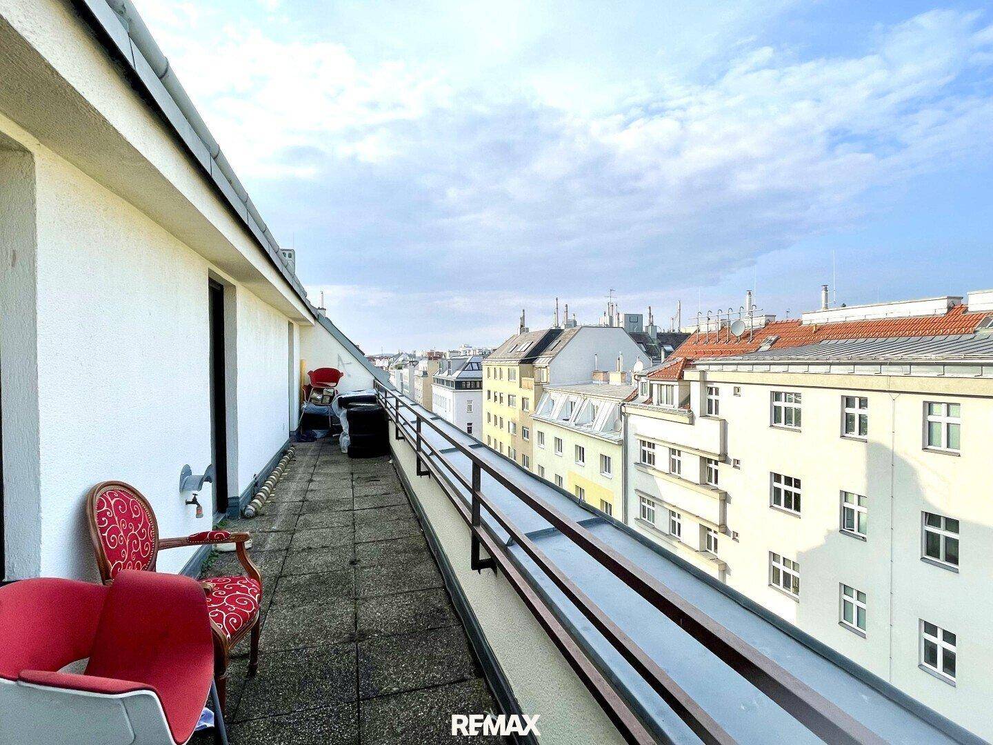 Langer Balkon mit Stadtblick und Sitzgelegenheiten, ideal für entspannte Stunden im Freien.