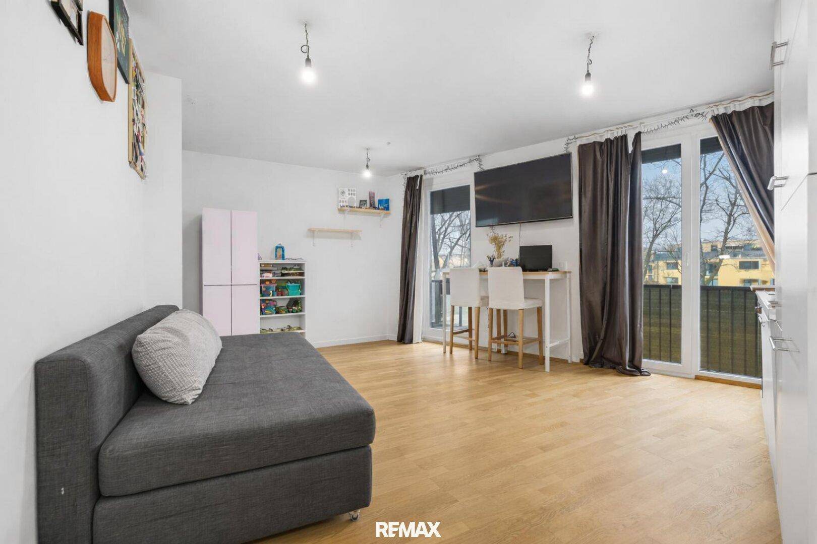 Gemütlicher Wohnbereich mit Sofa, Bartresen und großen Fenstern für viel Tageslicht und Balkonzugang.