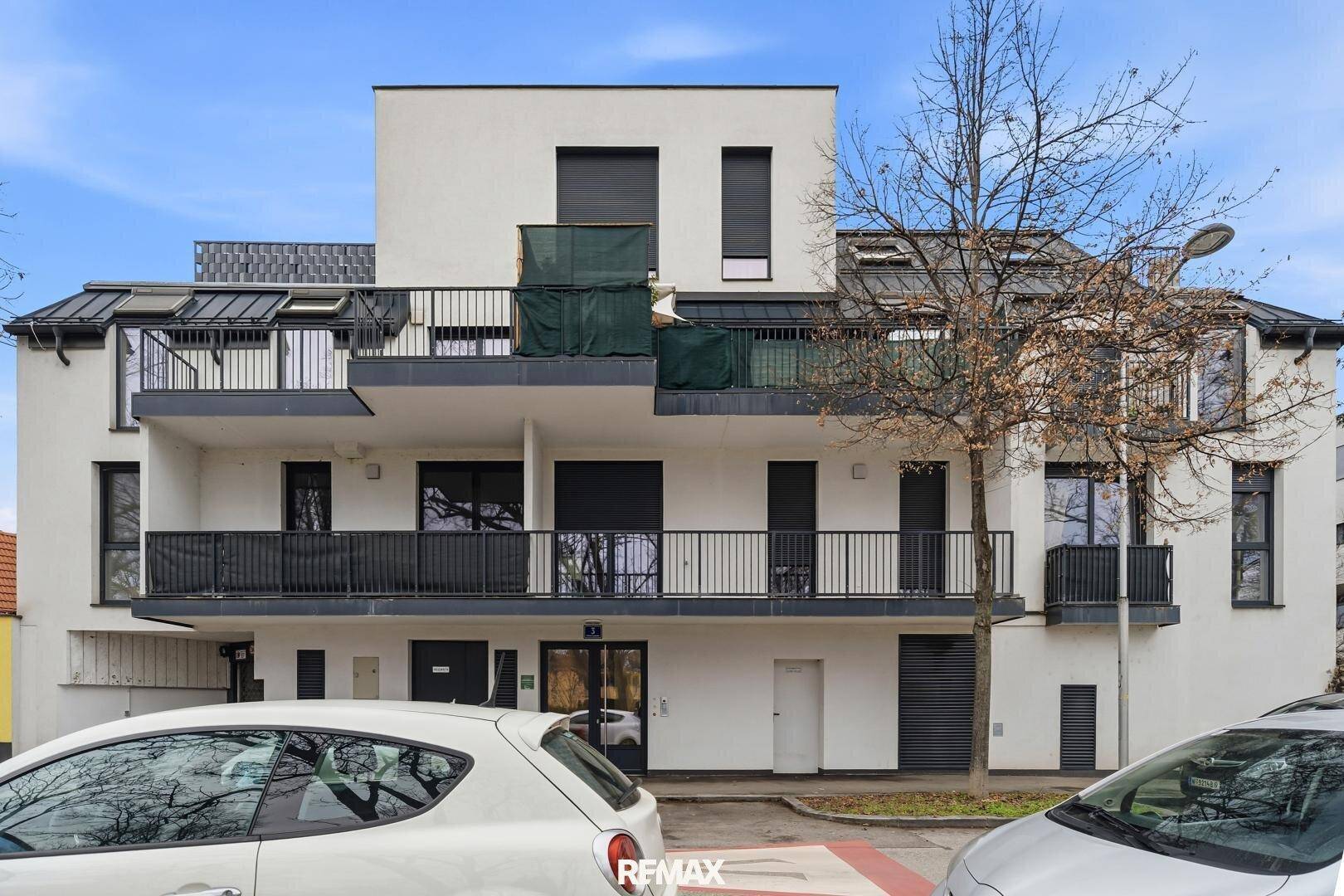Moderne Wohnhausfassade mit Balkonen und großen Fenstern, die viel Licht hereinlassen.