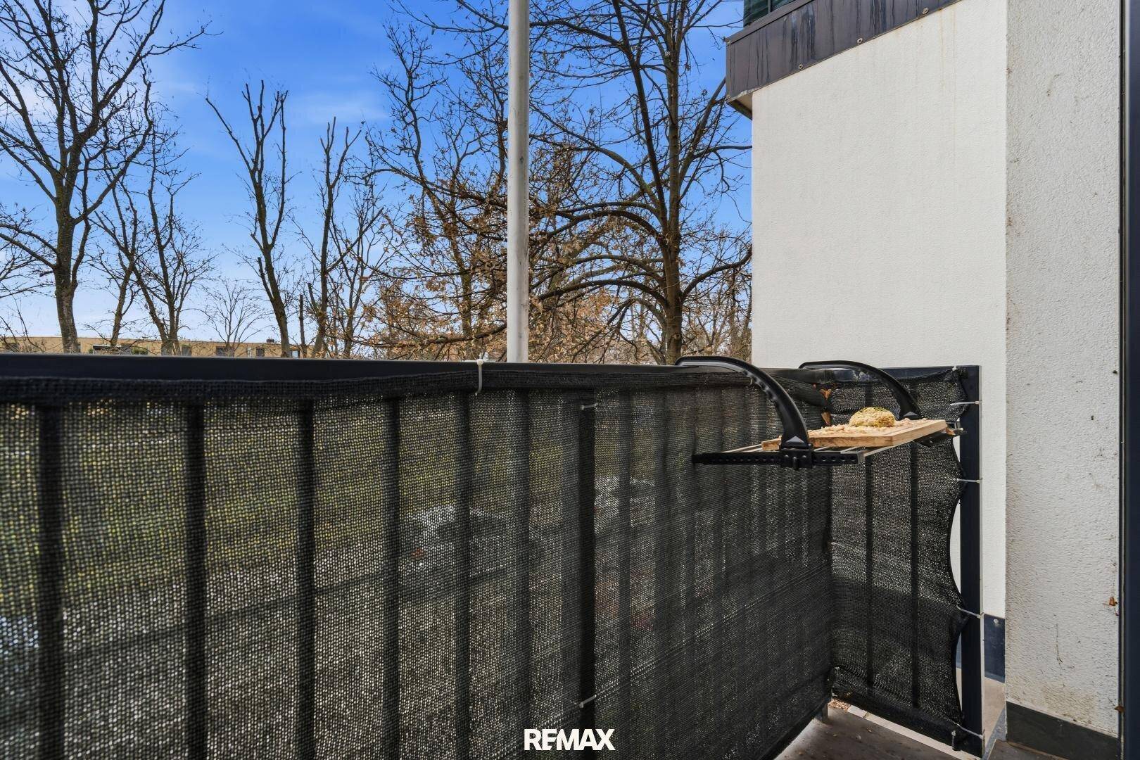 Balkon mit schwarzem Sichtschutz und Blick ins Grüne, ideal für entspannte Stunden.