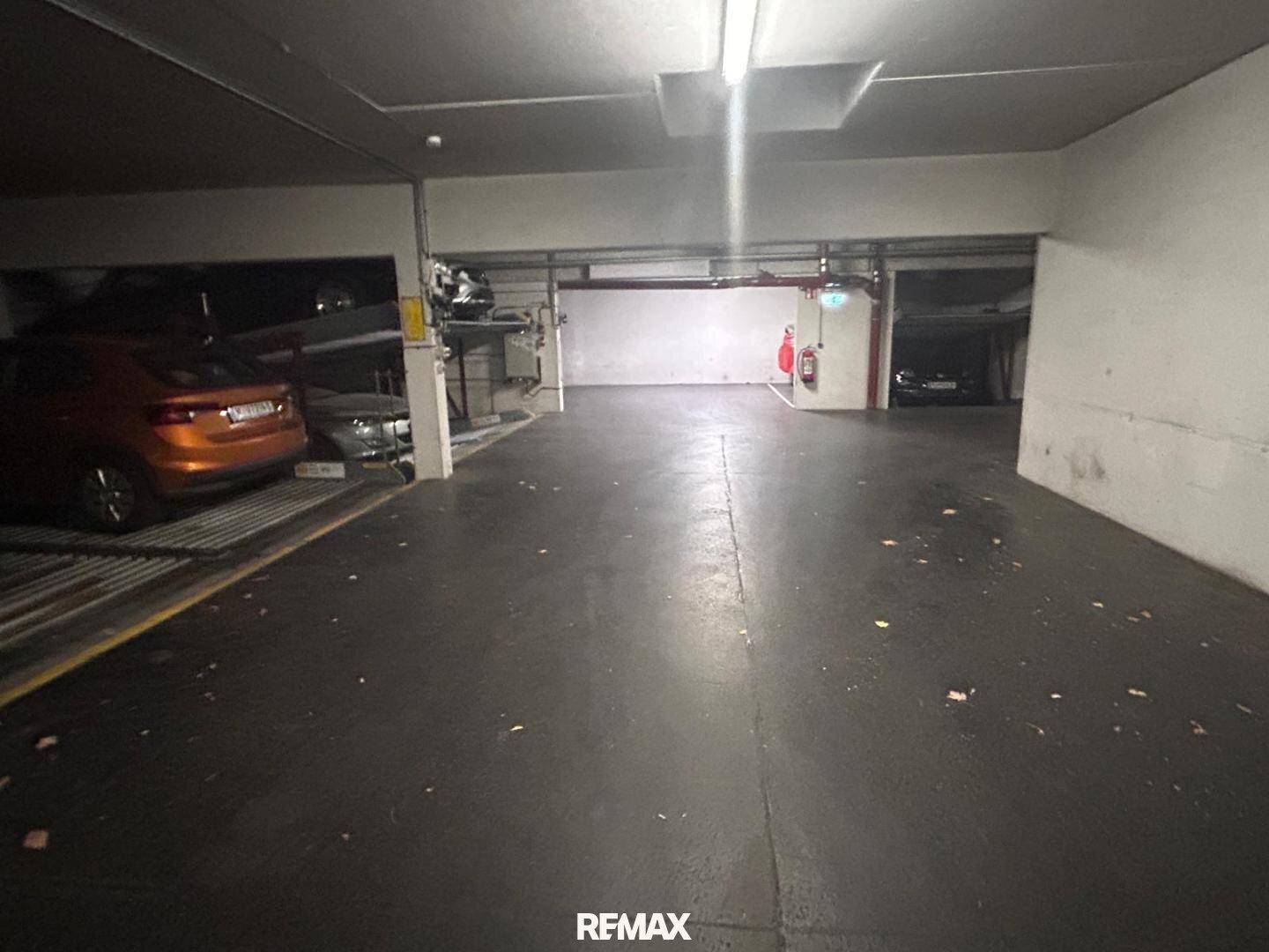 Dunkle Tiefgarage mit Betonboden und einem automatischen Parksystem.