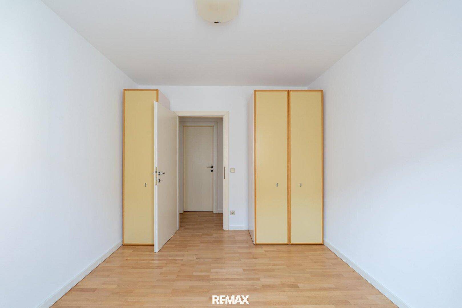 Zimmer mit hellen Einbauschränken und Holzboden, ideal als Schlaf- oder Gästezimmer.