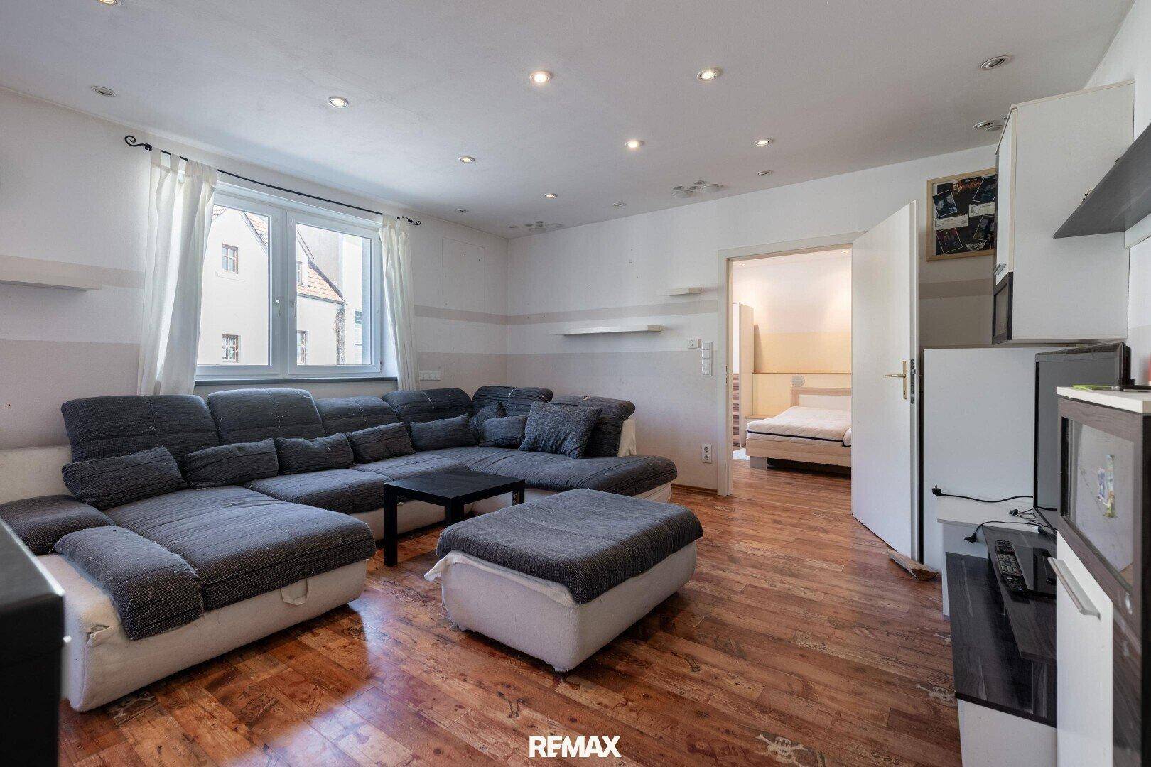 Gemütliches Wohnzimmer mit großem Ecksofa und Zugang zu einem weiteren Zimmer.