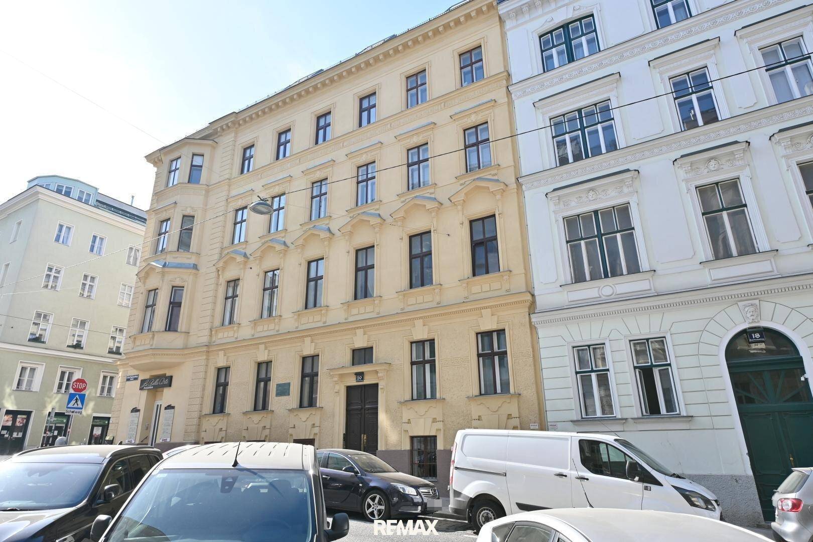 Klassisches Wohngebäude in der Stadt mit traditioneller Fassade und großen Fenstern.