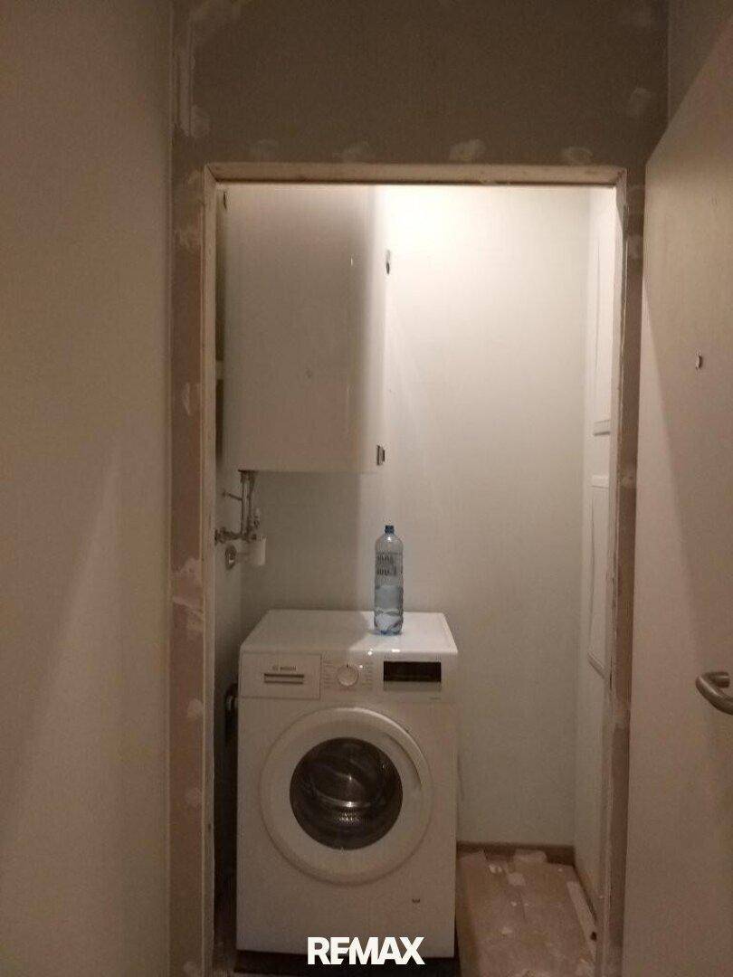 Kleiner Hauswirtschaftsraum mit Waschmaschine und Boiler.