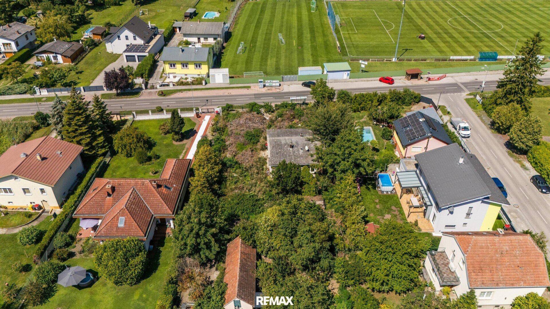 Luftaufnahme des Grundstücks mit dem Haus, umgeben von viel Grün und weiteren Wohnhäusern.