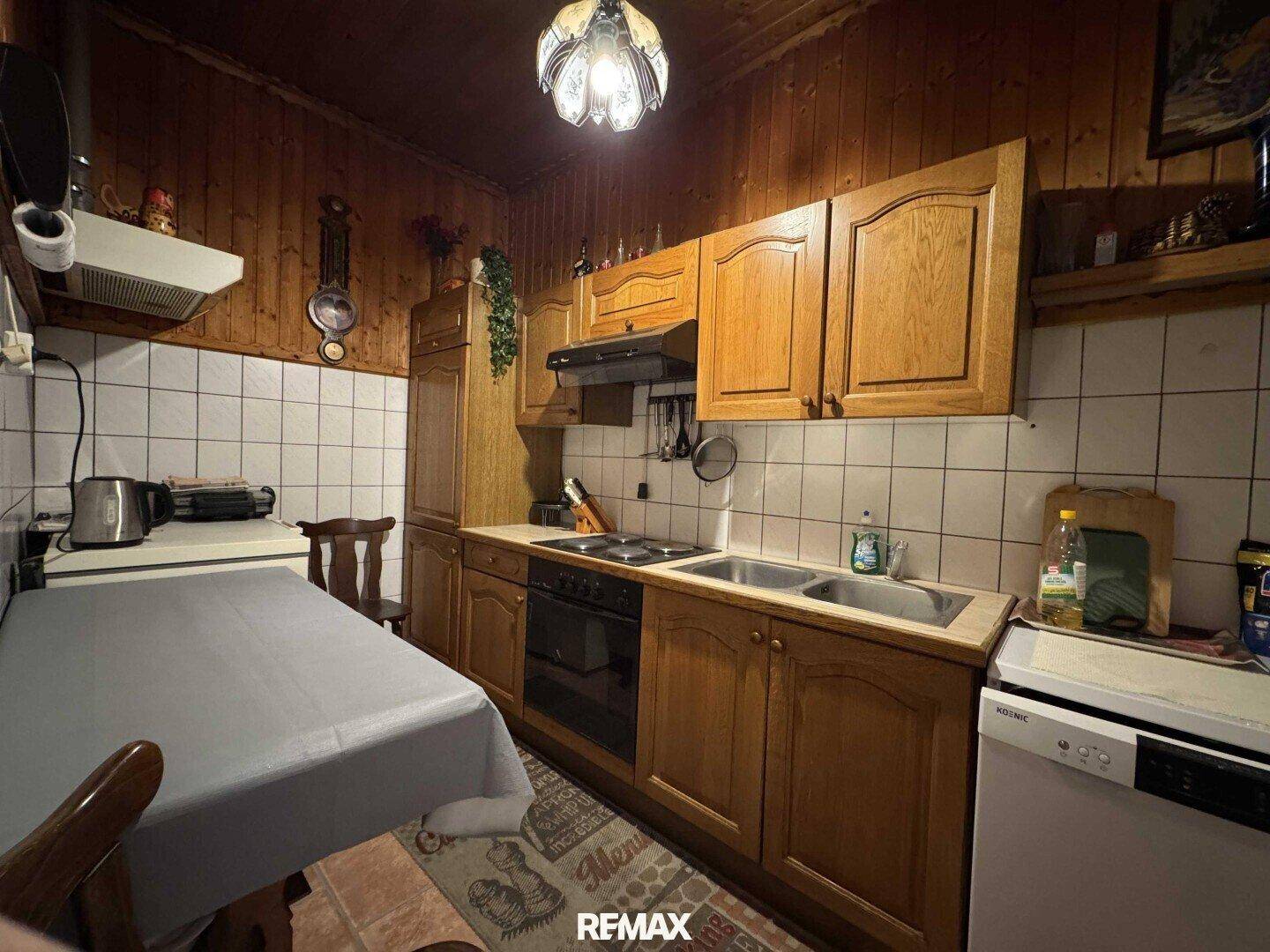 Rustikale Küche mit Holzvertäfelung, weißen Fliesen und einfacher Ausstattung.