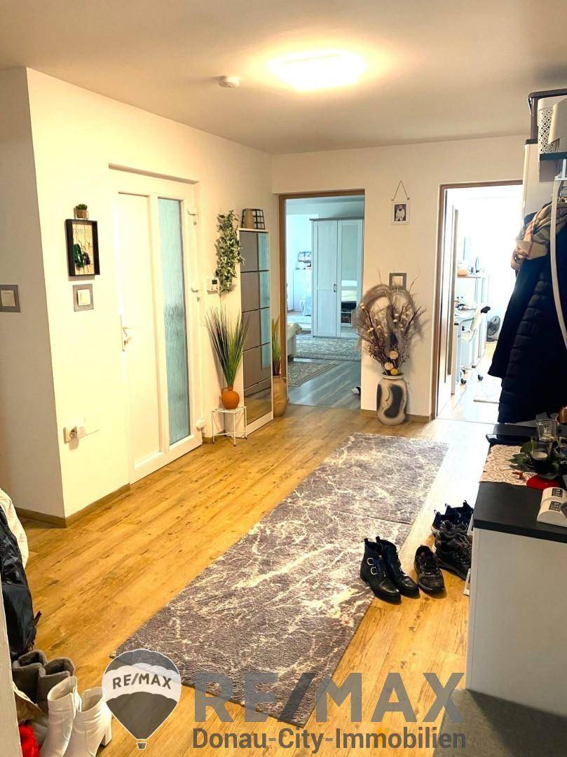 Heller Flur mit Laminatboden, Garderobe und Zugang zu weiteren Räumen.