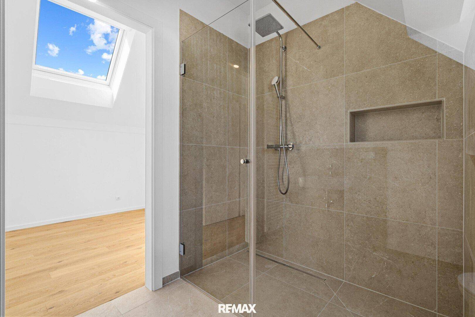 Moderne begehbare Dusche mit Glaswand und Regenduschkopf im Dachgeschoss-Badezimmer.