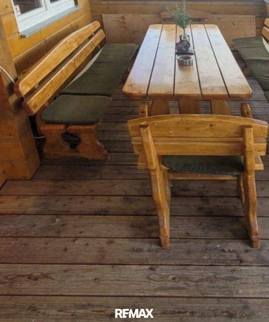 Rustikale Holzmöbel auf einer Terrasse, ideal für Mahlzeiten im Freien.