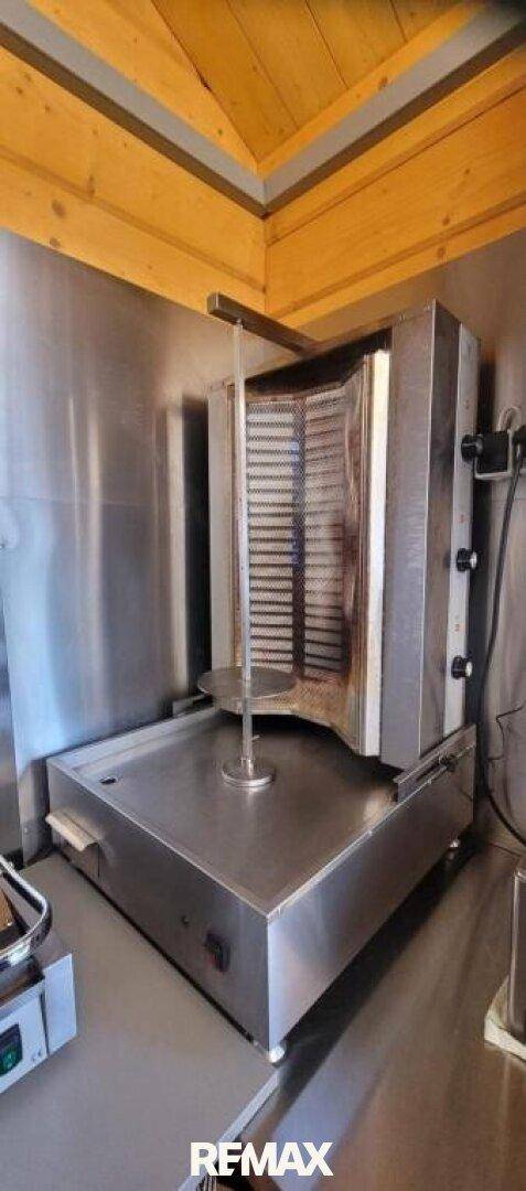 Professioneller Dönergrill aus Edelstahl in einer Imbissküche.