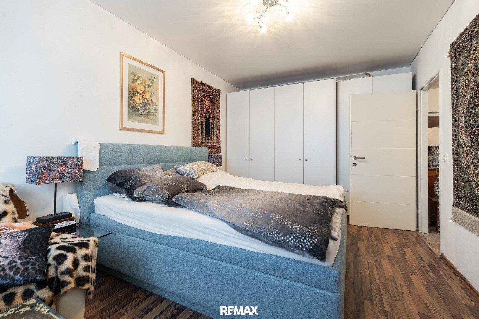Schlafzimmer mit Doppelbett, Einbauschränken und Holzboden.