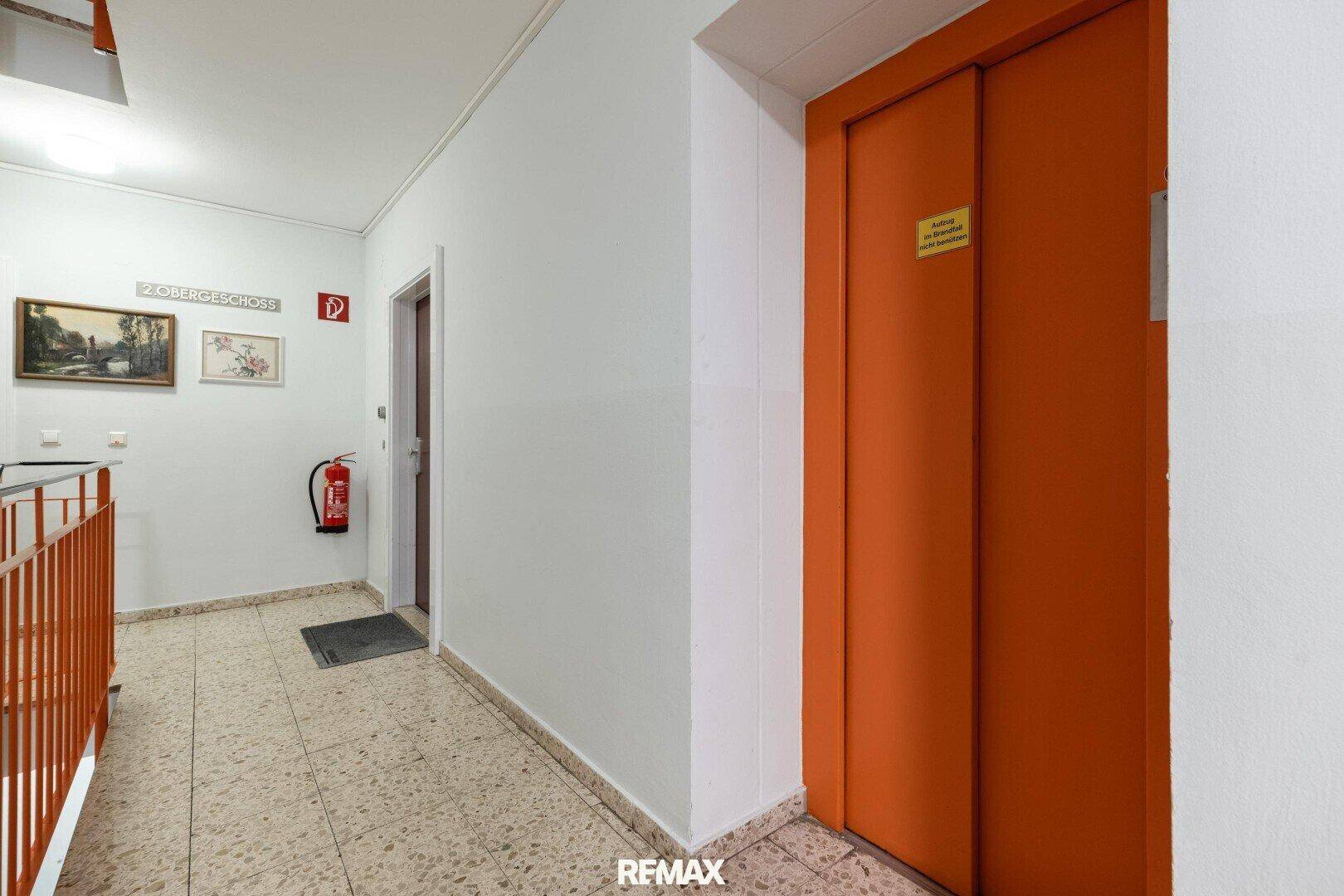Flur im Mehrfamilienhaus mit Aufzug und Treppenhaus.
