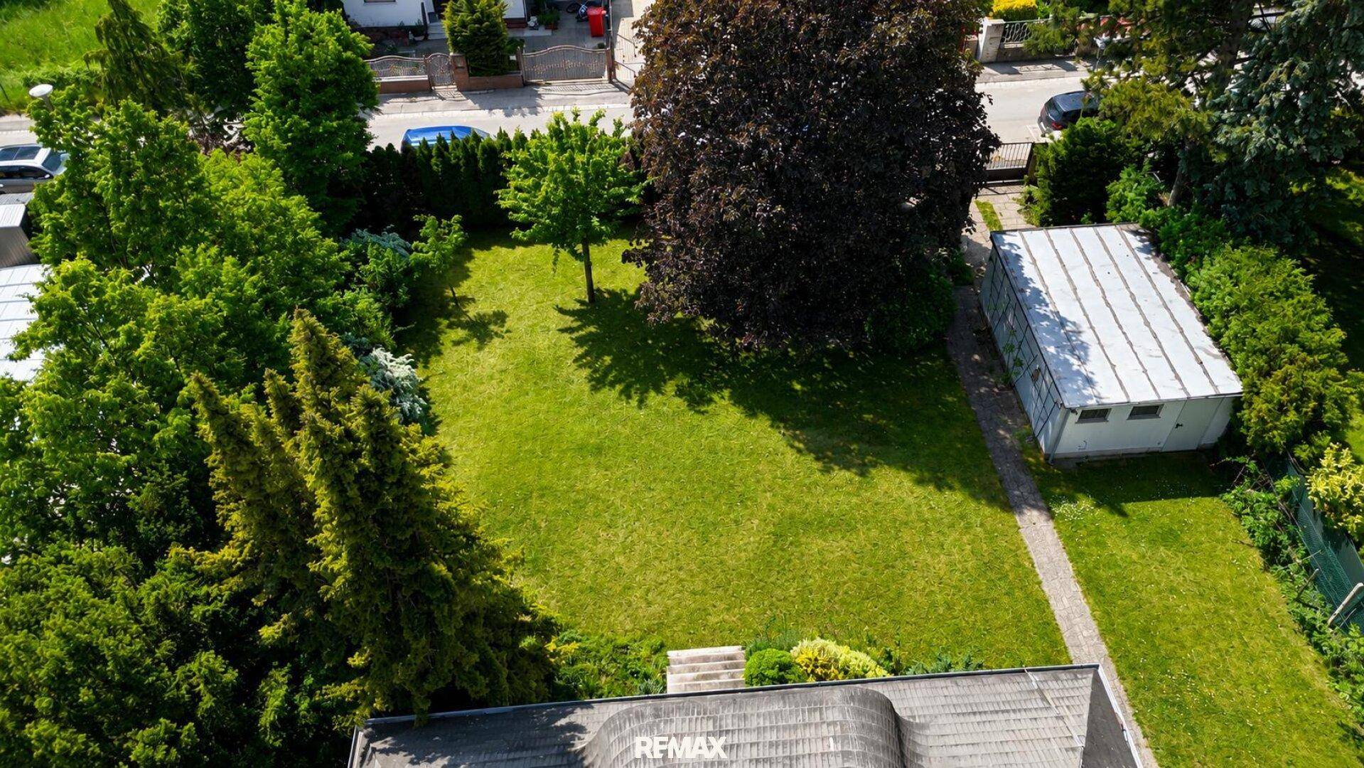 Luftaufnahme des Grundstücks mit Haus, großem Garten und umliegender Bebauung.