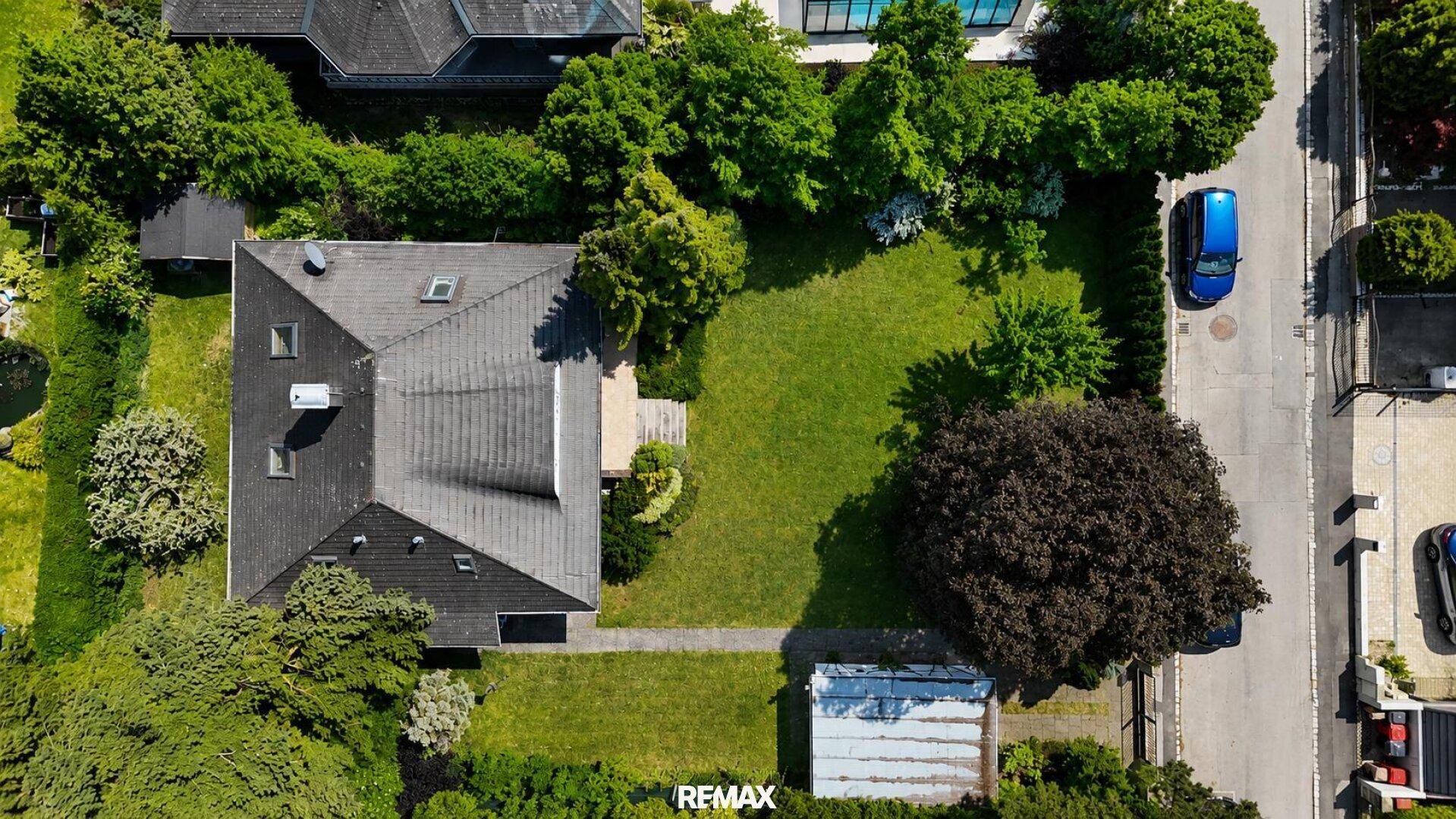 Vogelperspektive des Anwesens mit großem Garten, Haus und angrenzender Straße.