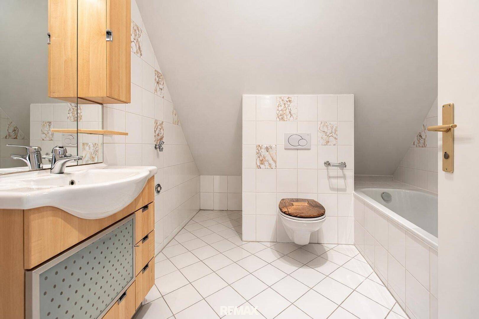 Badezimmer im Dachgeschoss mit Badewanne, WC und Dachschräge.