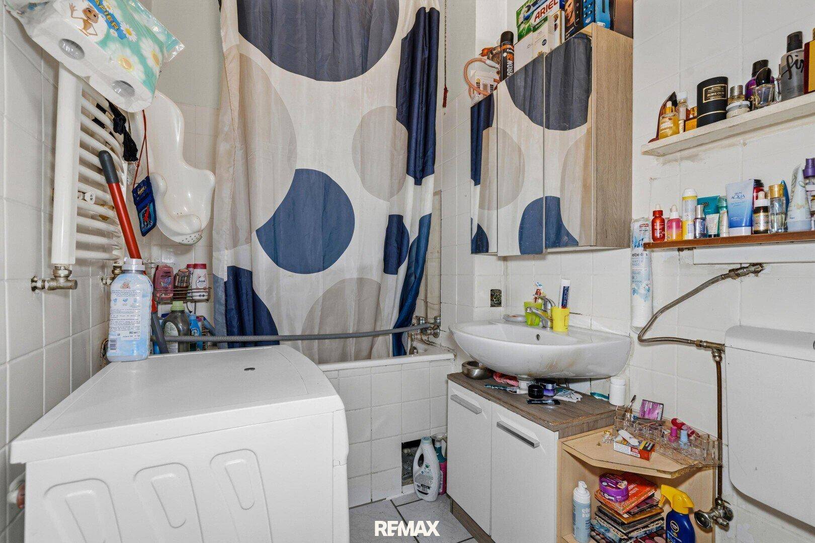 Badezimmer mit Badewanne, Waschmaschine, Toilette und Waschbecken.