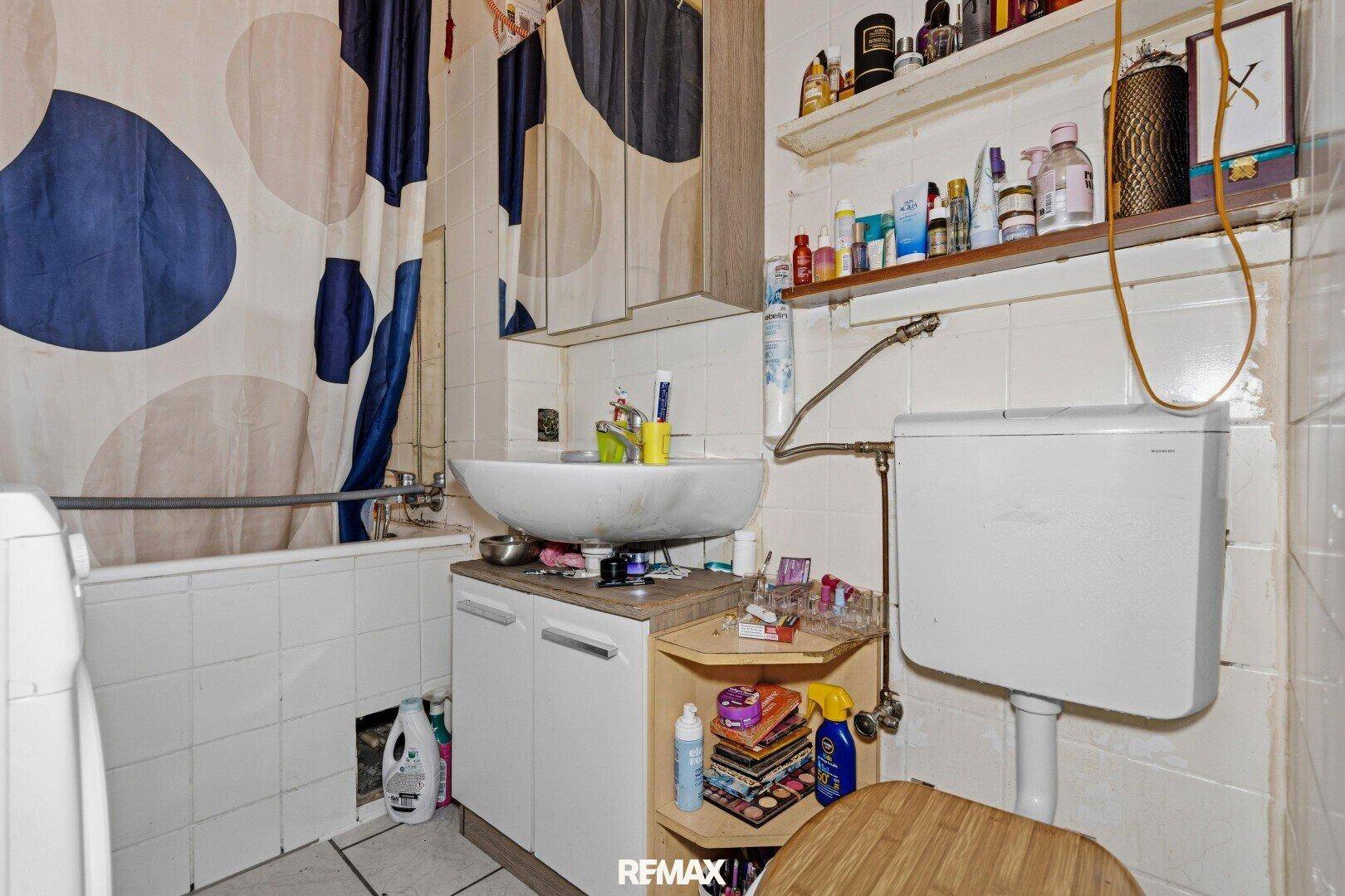 Badezimmer mit Badewanne, Toilette, Waschbecken und Fliesenboden.