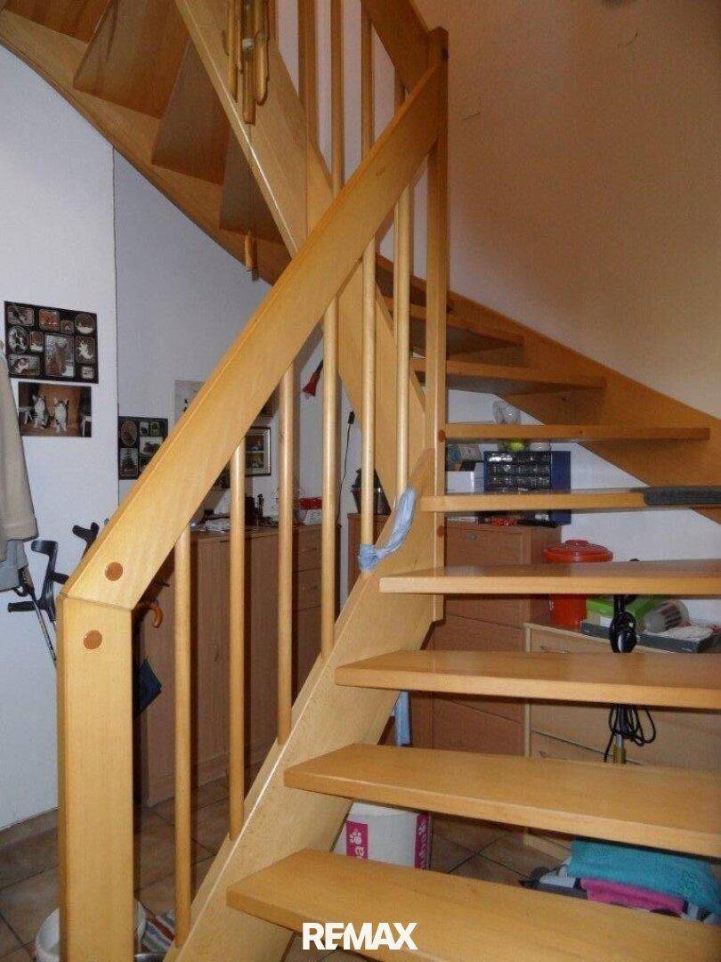 Helle Holztreppe mit Geländer, die die verschiedenen Etagen des Hauses verbindet.
