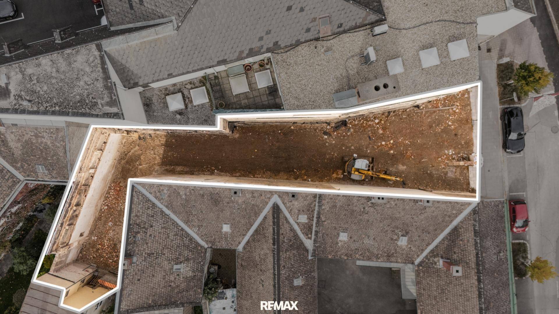 Luftaufnahme einer geräumten Baustelle, die den Umriss des zukünftigen Gebäudebereichs zeigt.