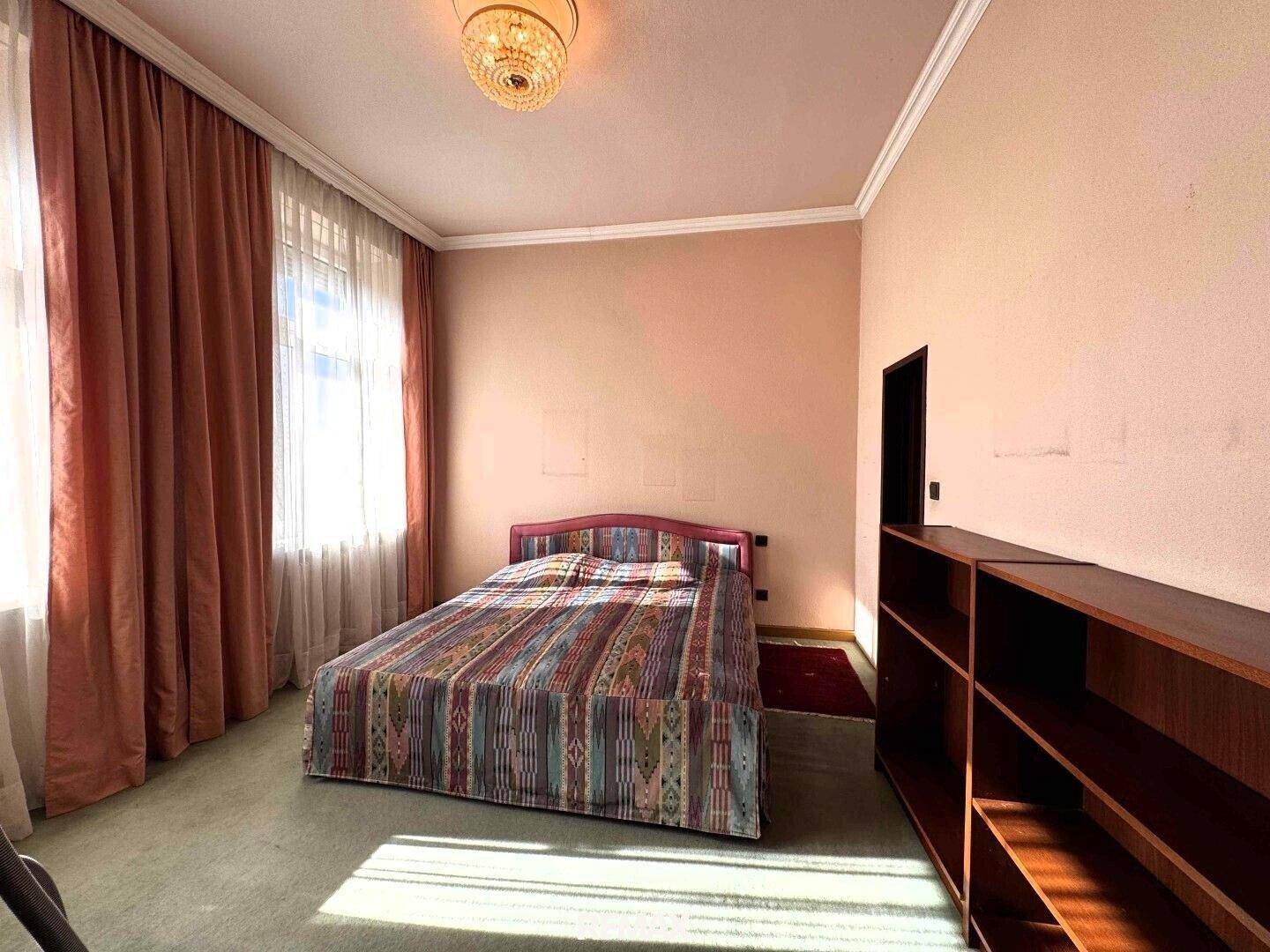 Schlafzimmer mit Doppelbett, Teppichboden und großen Fenstern, die für viel Helligkeit sorgen.