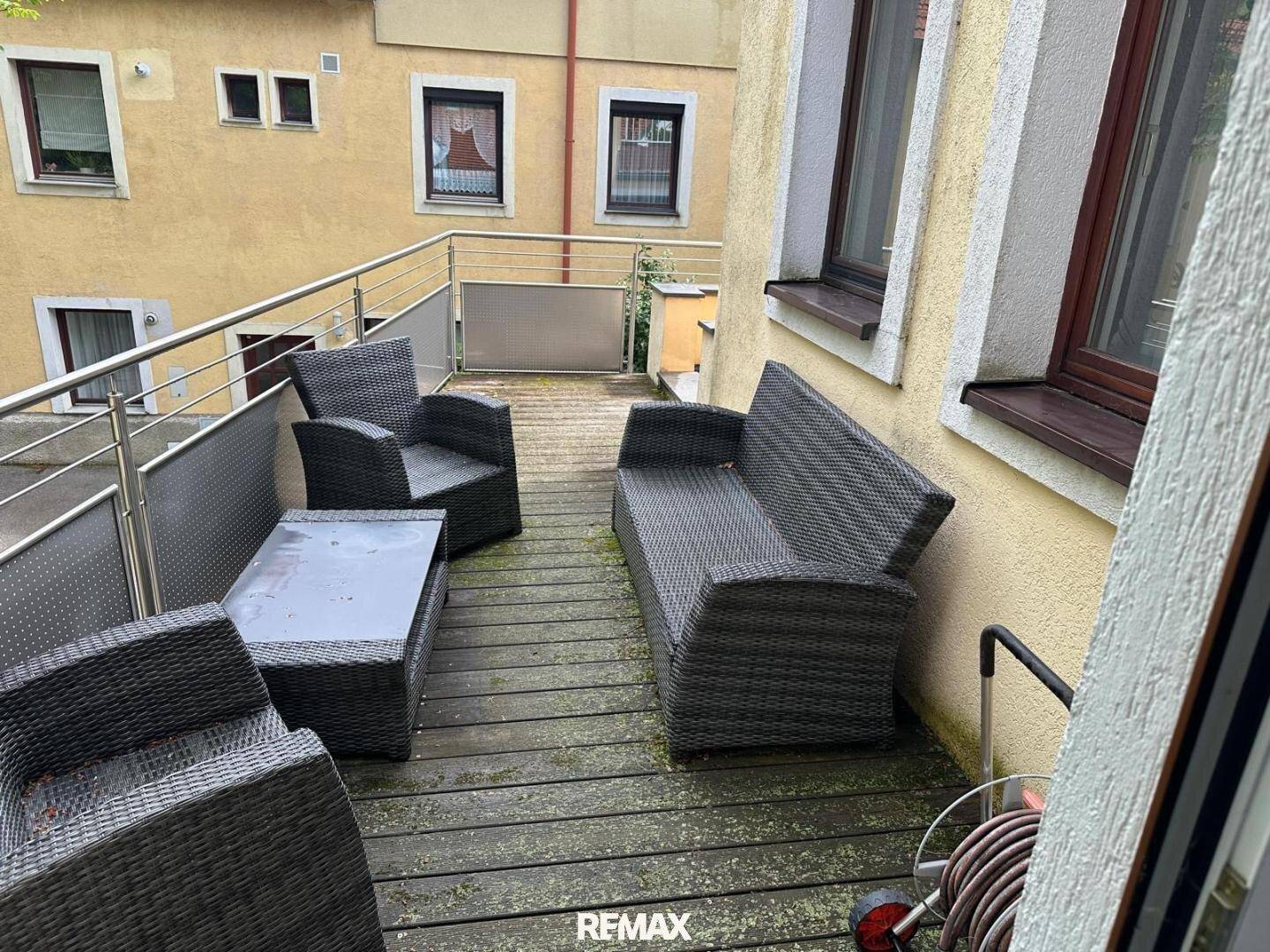 Geräumiger Balkon mit Rattanmöbeln und Blick auf die Umgebung.