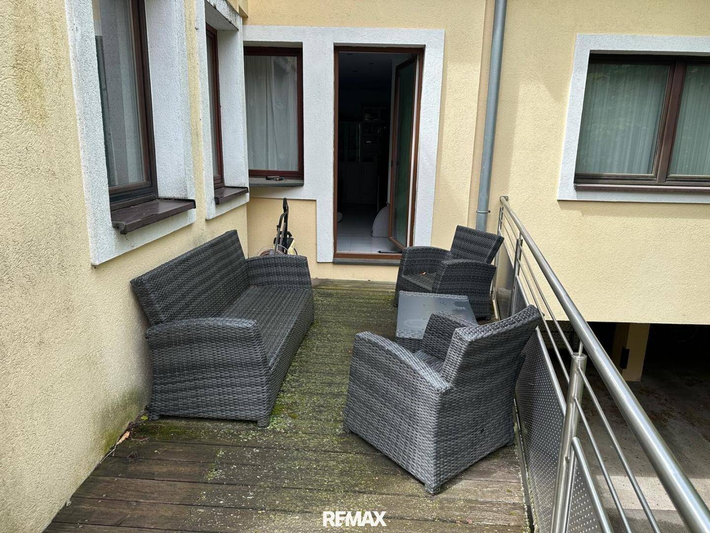 Balkon mit Holzbelag und Outdoor-Sitzgruppe, ideal für Entspannung im Freien.