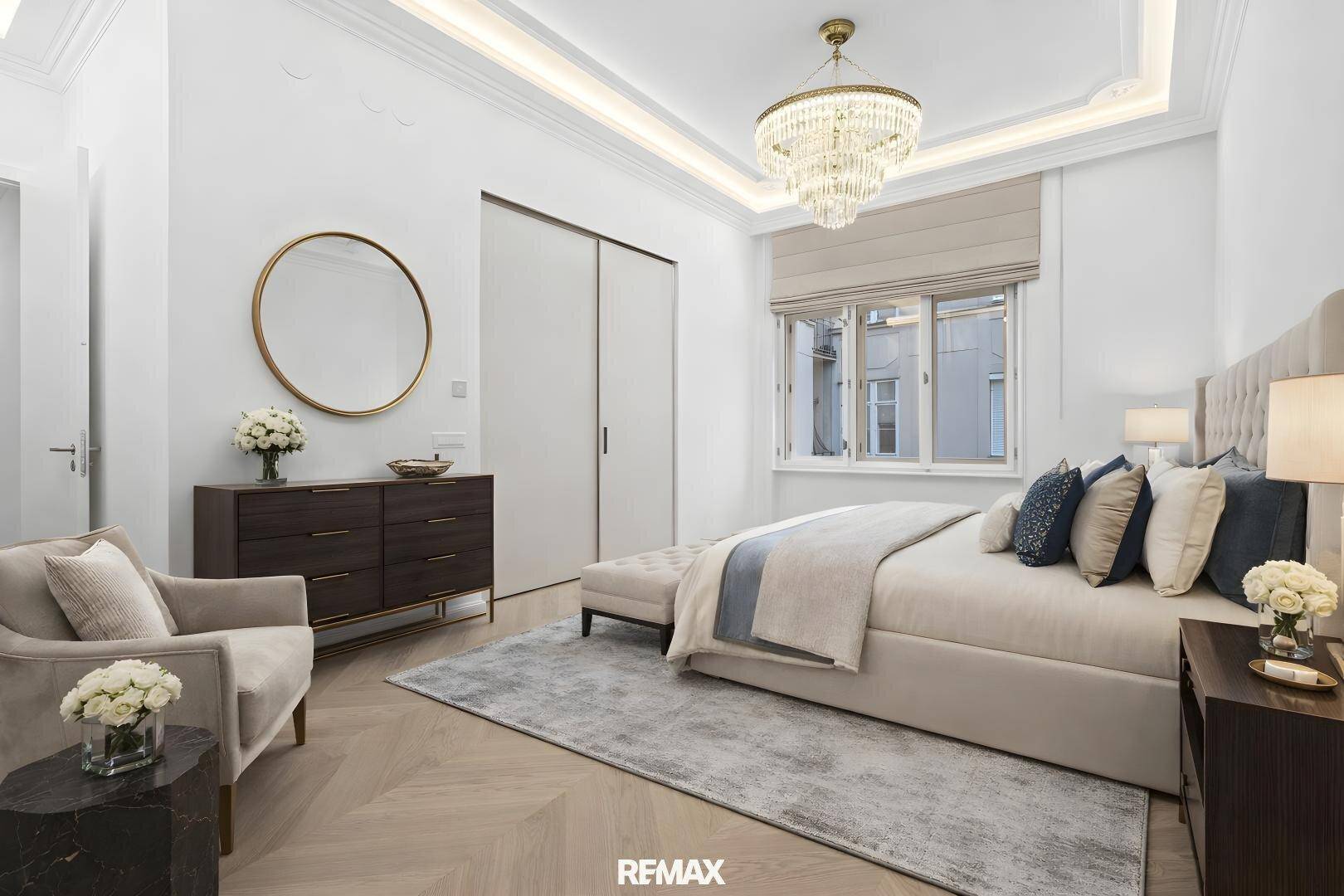 Elegantes Schlafzimmer mit Fischgrätparkett, Einbauschränken und Kronleuchter.