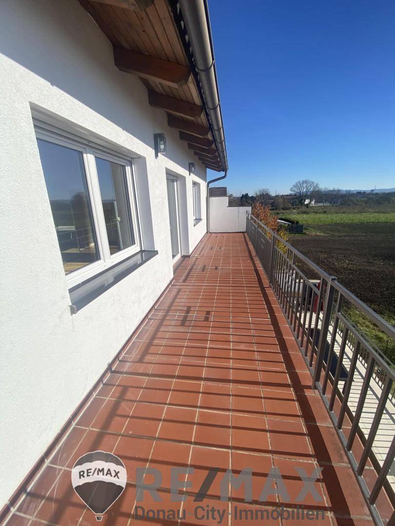 Langer Balkon mit Terrakotta-Fliesen und Metallgeländer, ideal für Entspannung im Freien.