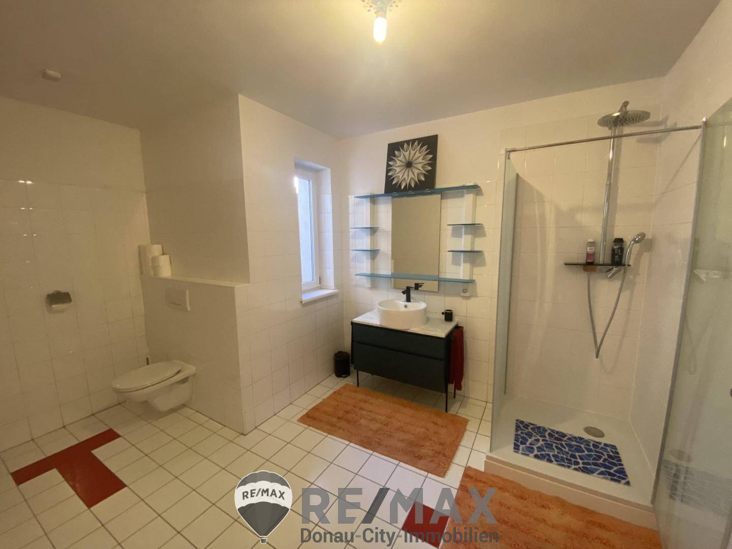 Modernes Badezimmer mit begehbarer Dusche, Hänge-WC und stilvollem Waschtisch.