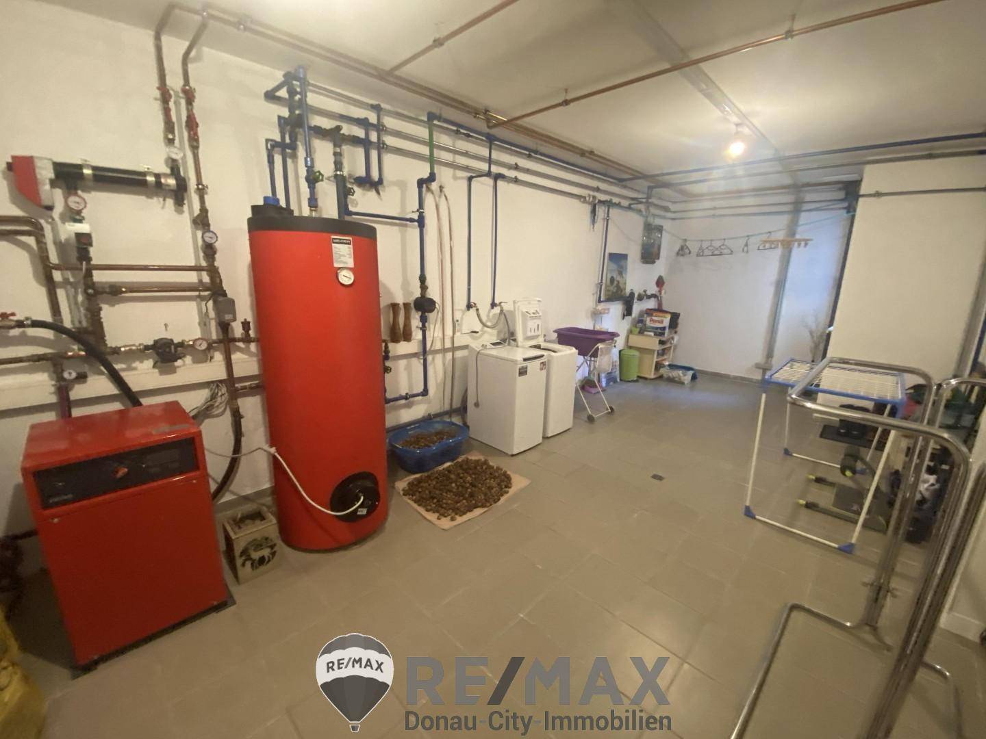 Technikraum mit Heizungsanlage, Warmwasserspeicher und Waschmaschinenanschluss.