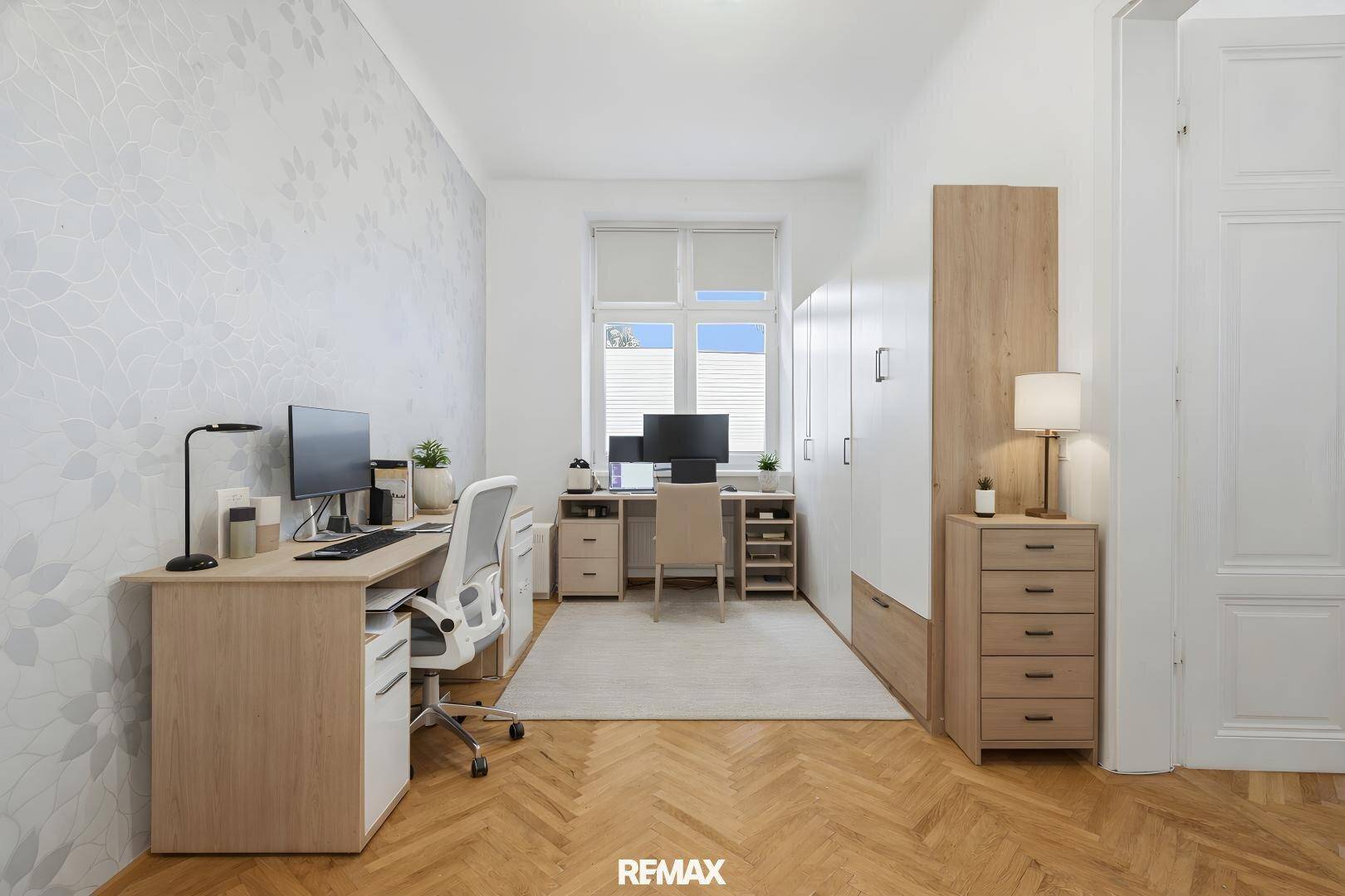 Helles Arbeitszimmer mit zwei Schreibtischen, Parkettboden und großen Fenstern für viel Licht.