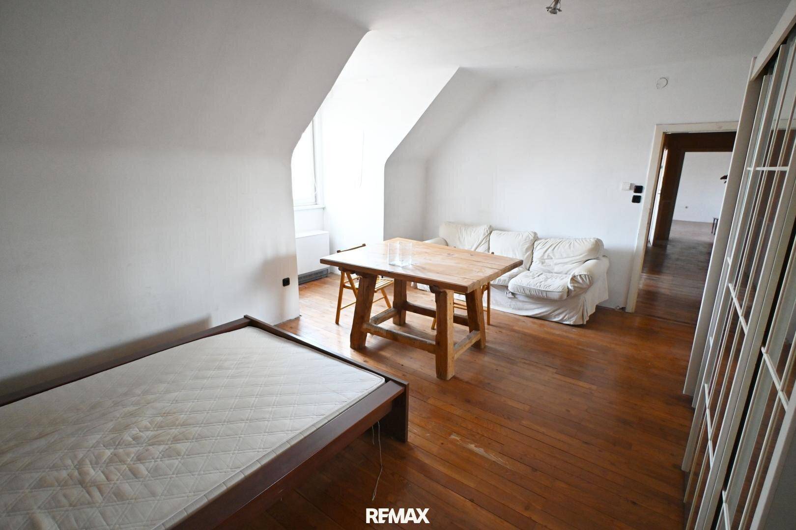 Geräumiges Schlafzimmer mit Holzdielenboden und Dachschräge, ideal für individuelle Gestaltungsmöglichkeiten.