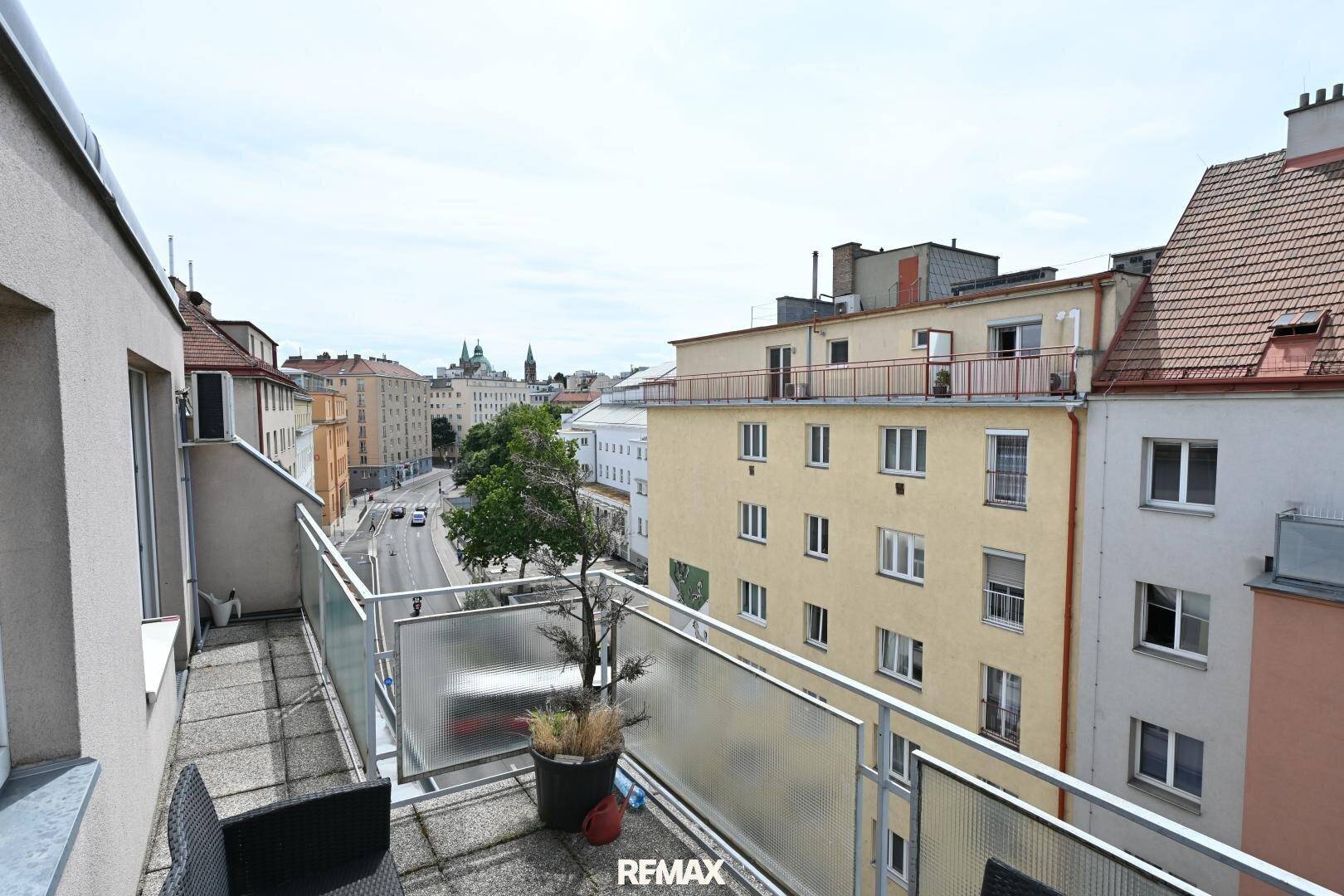 Weiter Blick vom Balkon über die Stadt mit umliegenden Gebäuden und Straßenverkehr.