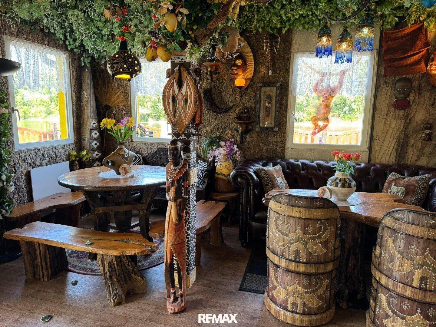Ein weiterer Blick in den Restaurantbereich mit rustikalen Holztischen, Bänken und einem Ledersofa.