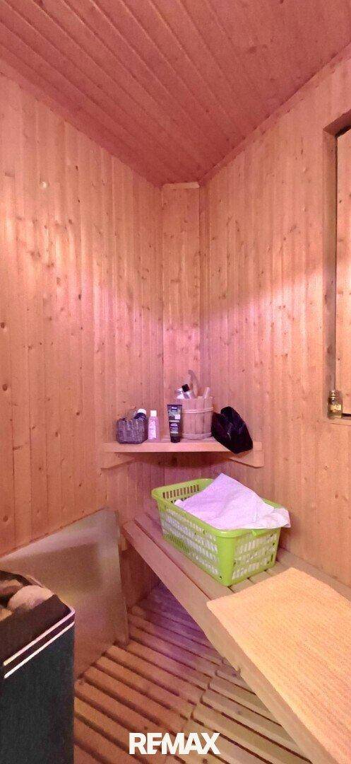 Traditionelle Holzsauna mit Bänken und einem Saunaofen für Entspannung.