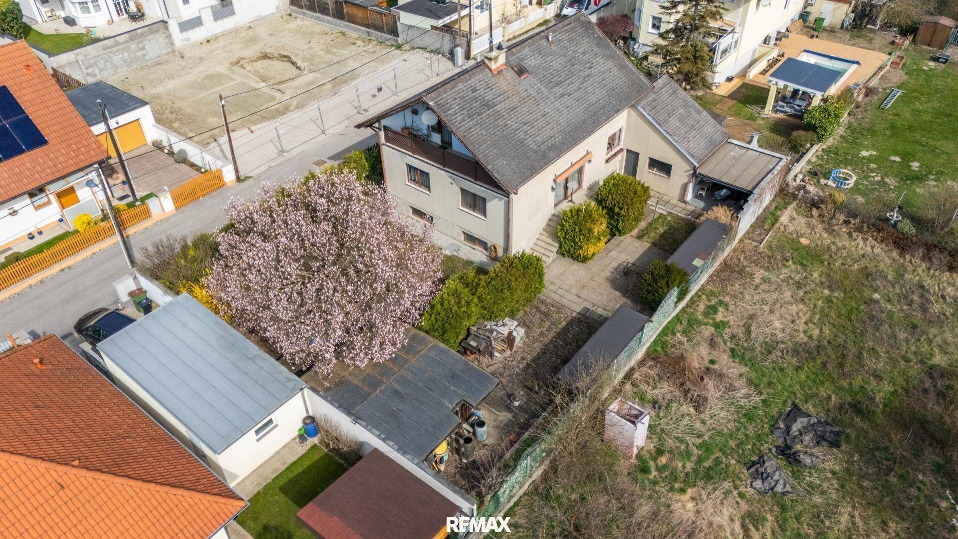 Weitläufige Luftaufnahme des Hauses mit Garten, Terrasse und angrenzenden Grundstücken.