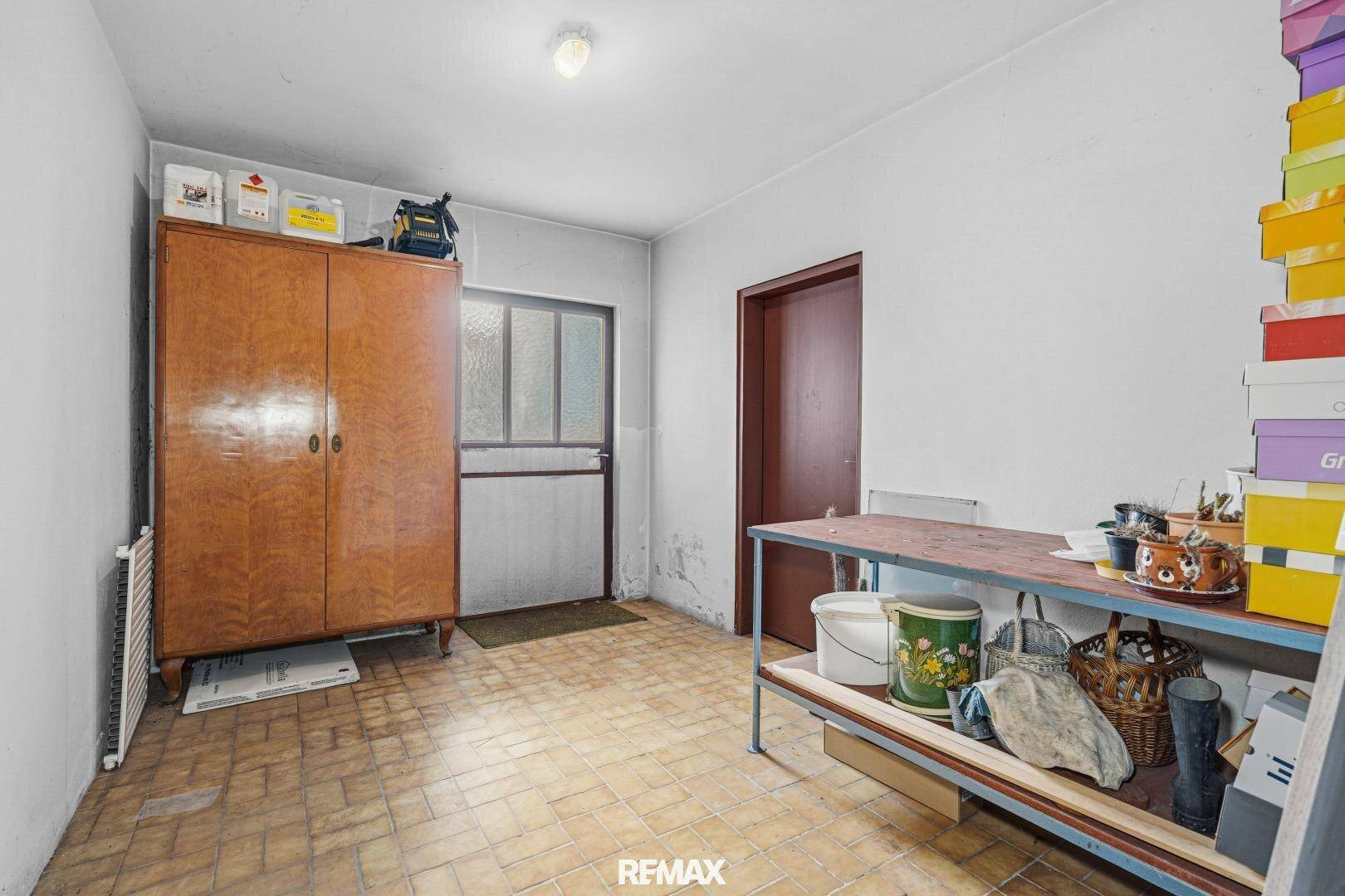 Abstellraum oder Werkstatt mit Schrank, Regal und gefliestem Boden.