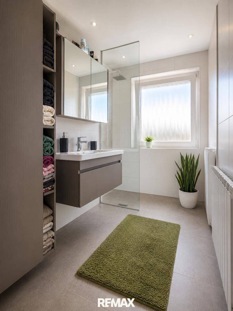 Modernes Badezimmer mit schwebendem Waschtisch, ebenerdiger Dusche und großem Fenster.