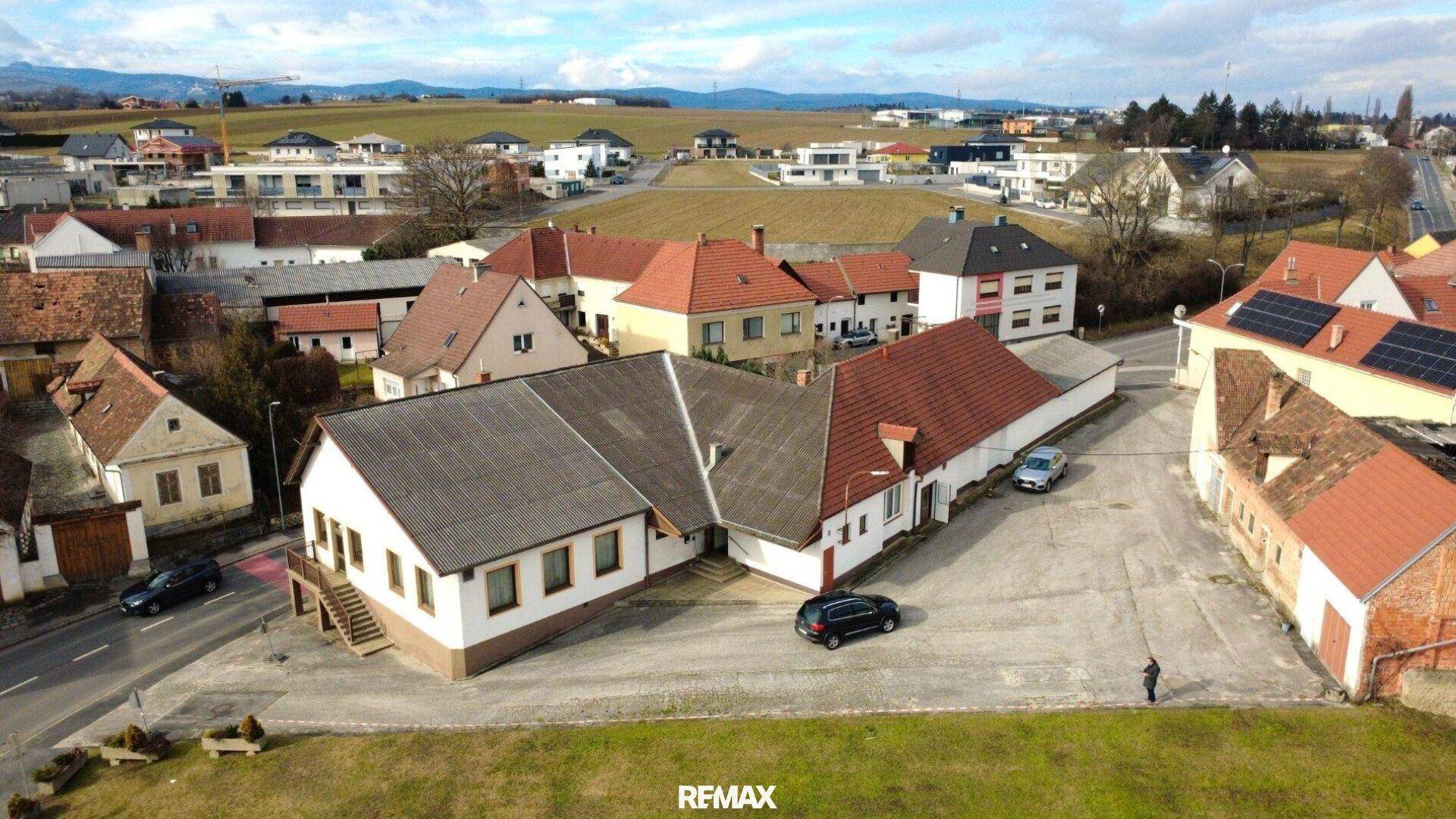 Weitläufige Luftaufnahme eines Anwesens mit mehreren Gebäuden und umliegender ländlicher Landschaft.