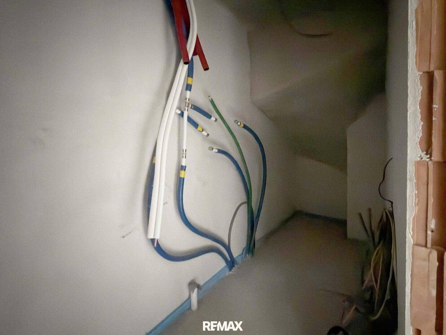 Rohbau-Bereich mit sichtbaren Installationen und Leitungen, bereit für die Verkleidung.