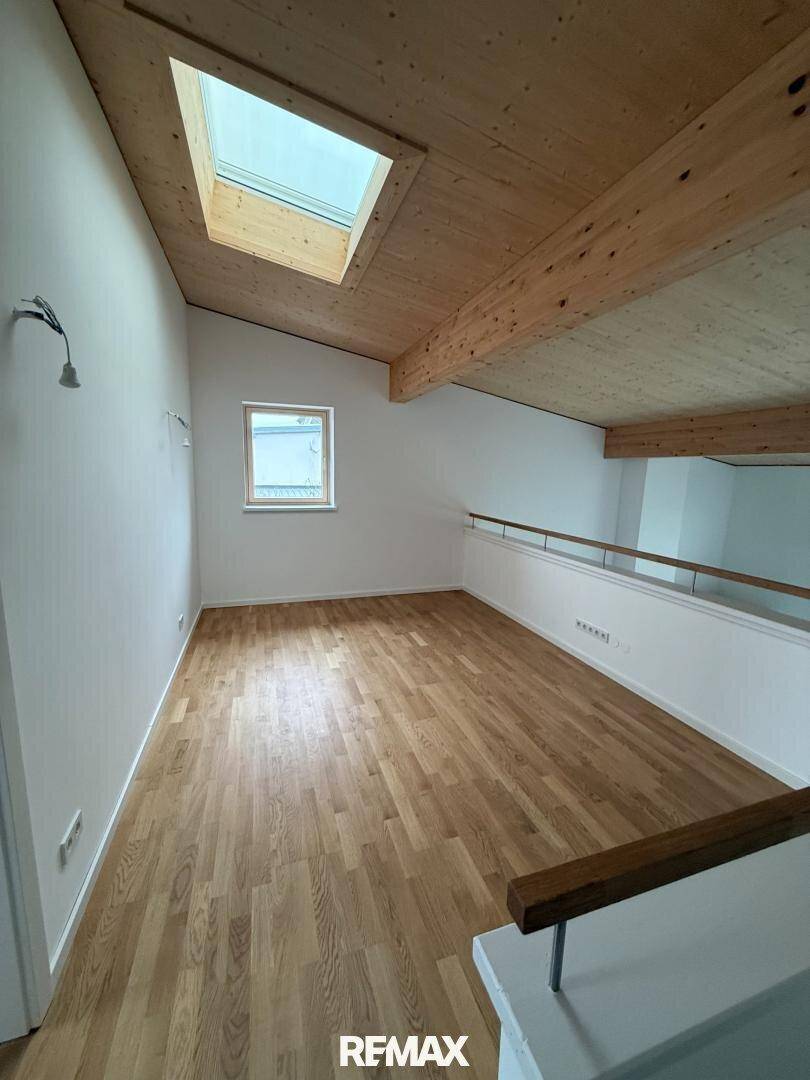 Offene Galerie im Obergeschoss mit Holzboden, Dachschräge und Oberlicht.