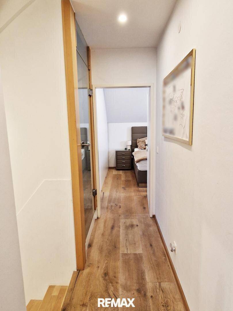 Heller Flur im Obergeschoss mit Holzboden und Zugang zu den Schlafzimmern.