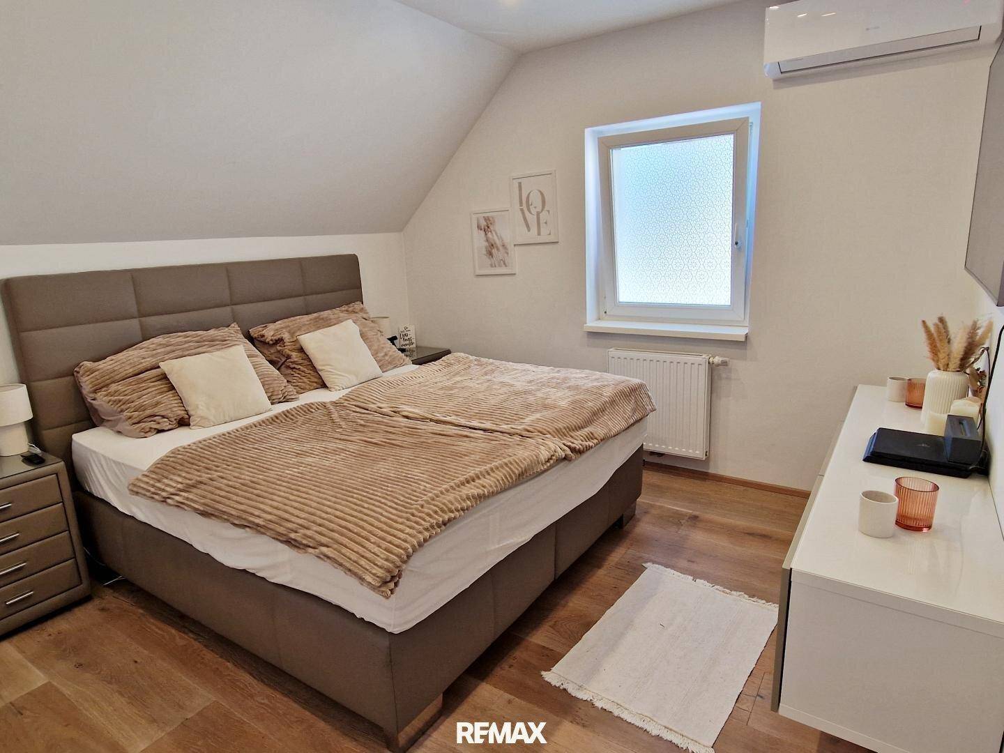 Gemütliches Schlafzimmer mit Doppelbett, Holzboden und Dachschräge, klimatisiert.