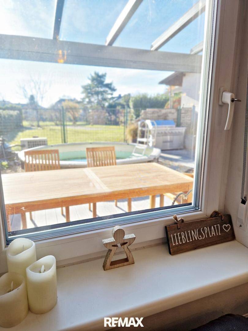 Fensterblick auf die Terrasse mit Whirlpool und Garten, ein sonniger Lieblingsplatz.