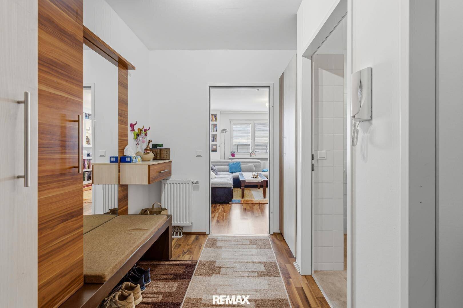 Heller Flur mit Holzelementen und Garderobe, führt in den Wohnbereich.
