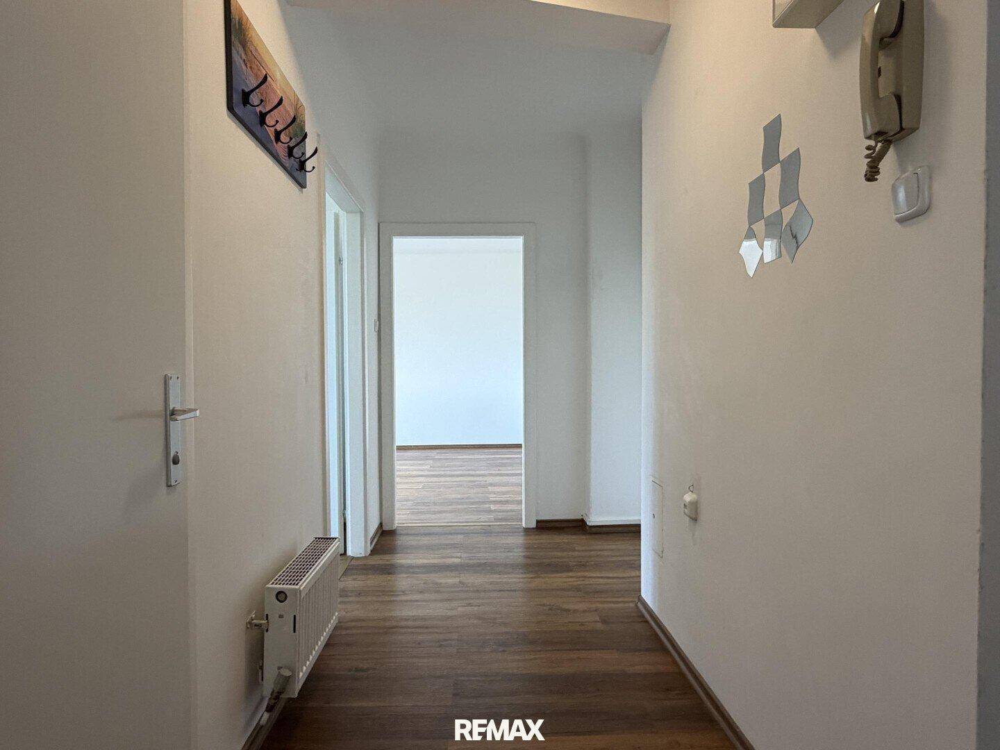 Langer Flur mit Laminatboden und Zugang zu verschiedenen Zimmern der Wohnung.