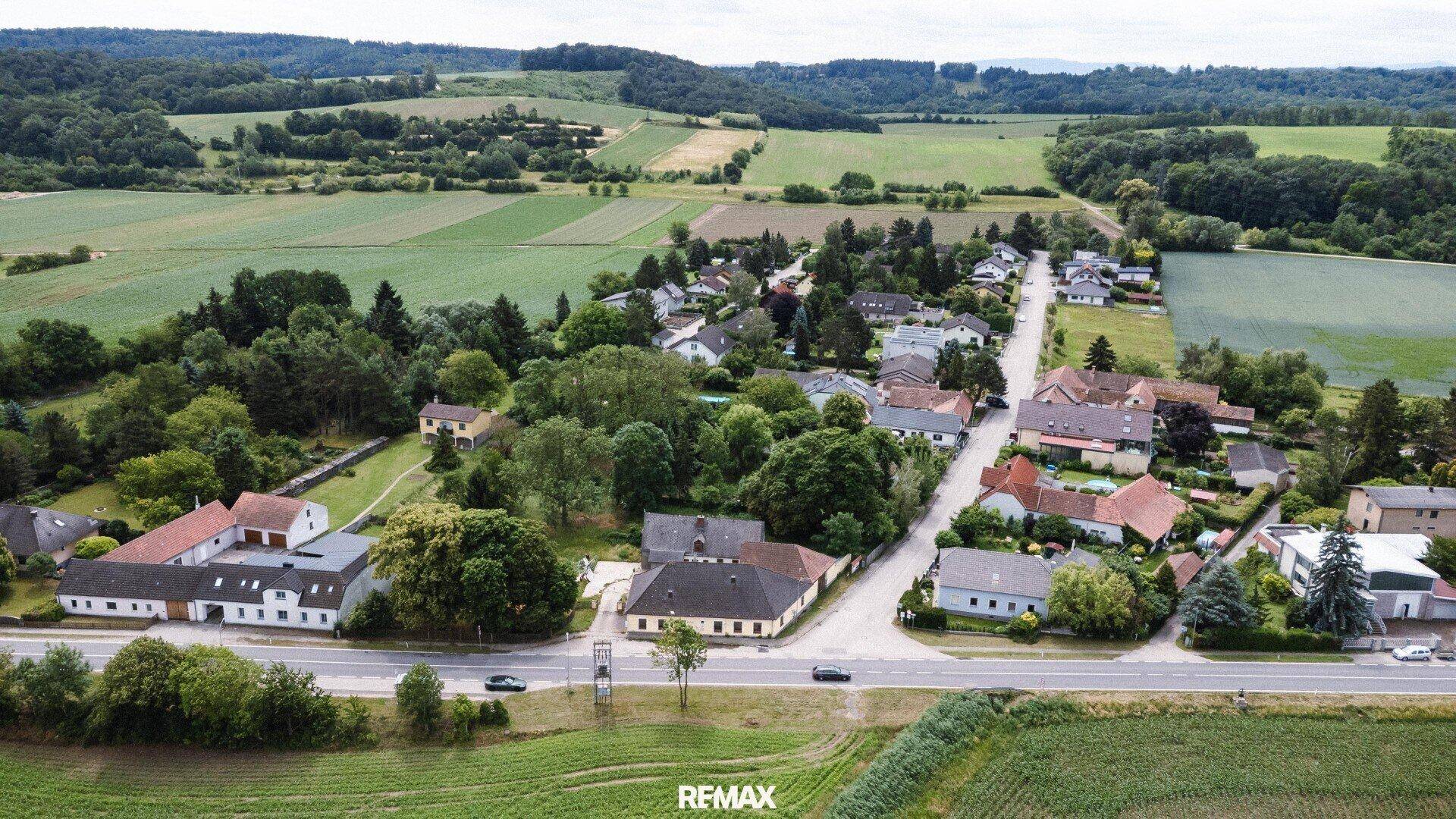 Übersichtliche Luftaufnahme des Grundstücks in der ländlichen Umgebung mit angrenzenden Feldern und Wald.