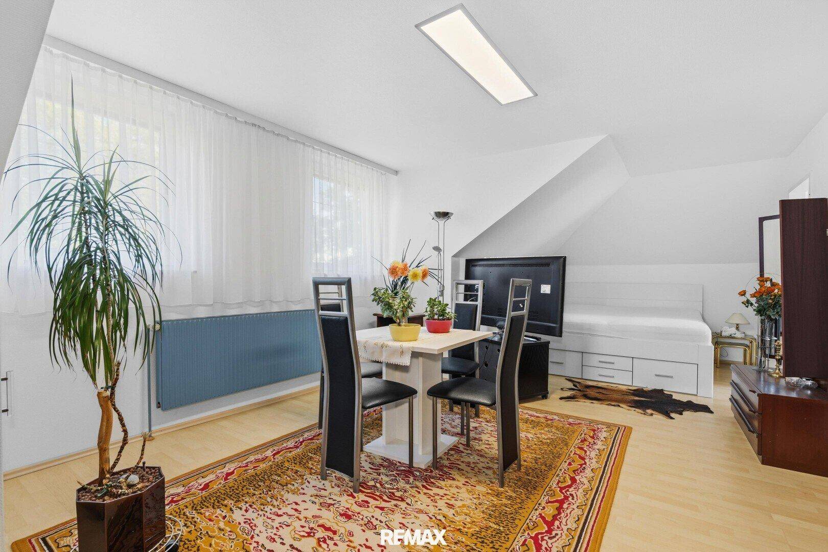 Gemütliches Dachzimmer mit schräger Decke, als Schlaf- und Wohnbereich genutzt.
